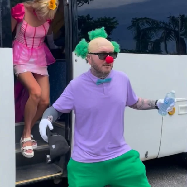 Person dressed as clown in colorful outfit, another stepping off a bus in pink dress.